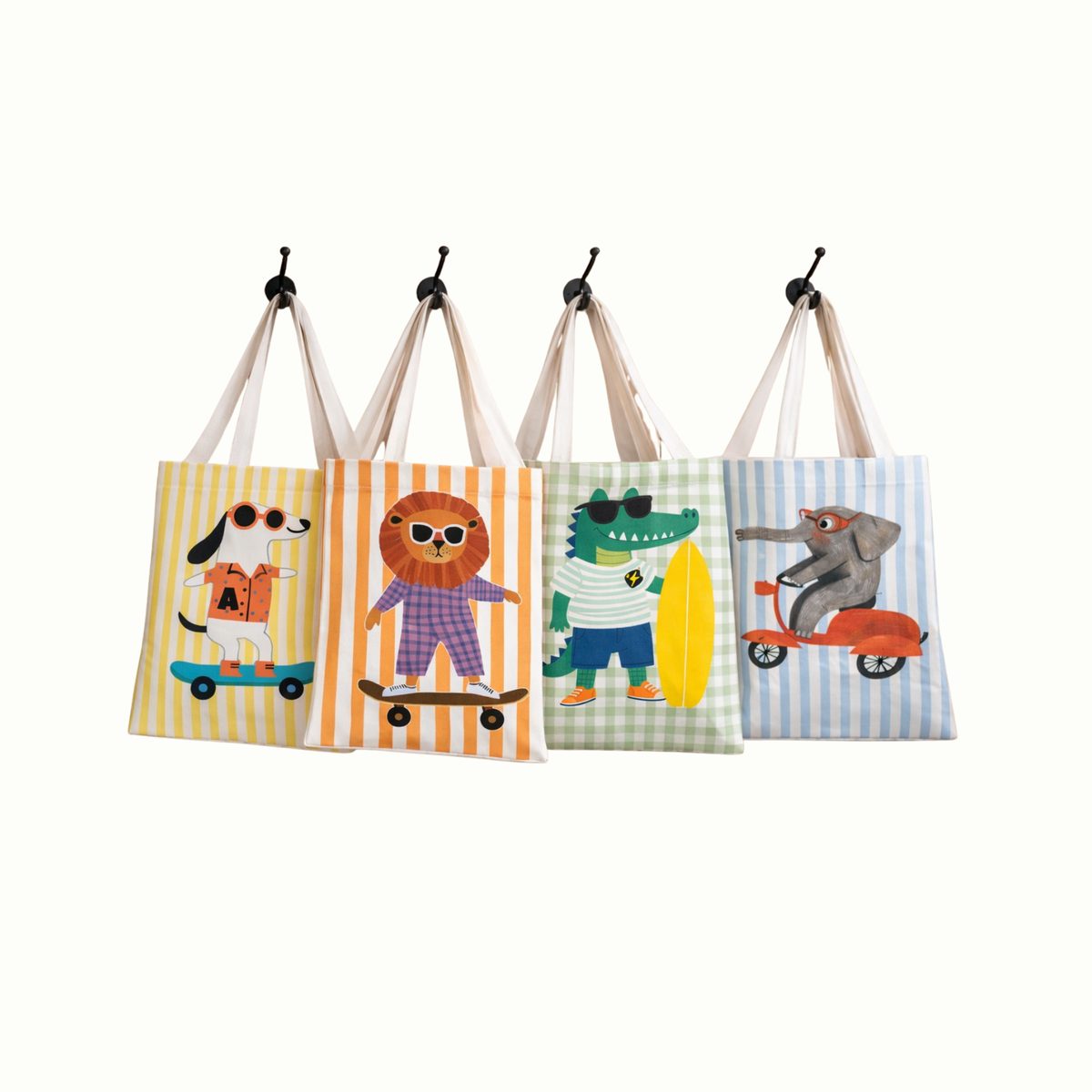 Cuatro tote bags de tela con animales ilustrados colgadas de ganchos